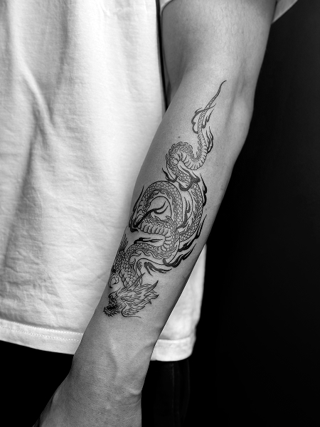 Tatuaż smoka na przedramieniu z detalami wykonany w No Mercy Żyrardów